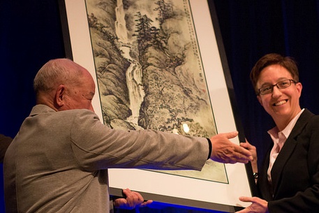 Portland artist Luo Jian presents a painting to Oregon House Speaker Tina Kotek.